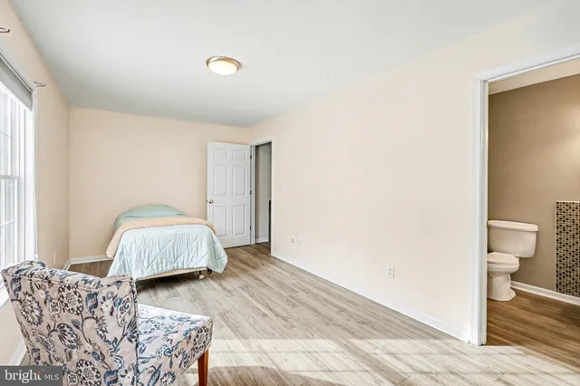 a spacious bedroom with a bed and a wooden floor