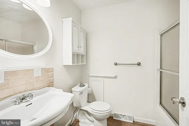 a bathroom with a sink a toilet and a mirror