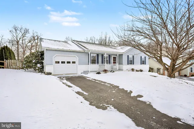 a front view of a house with a yard covered in snow