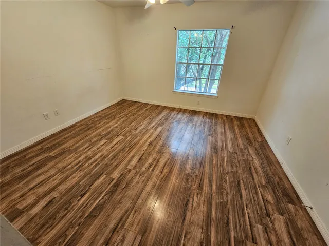 a view of a room with wooden floor and windows
