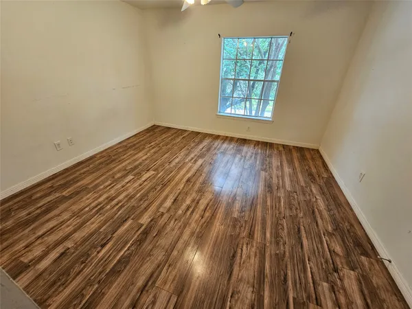 a view of a room with wooden floor and windows
