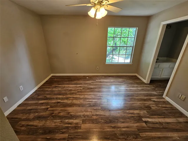 a view of empty room with window and wooden floor