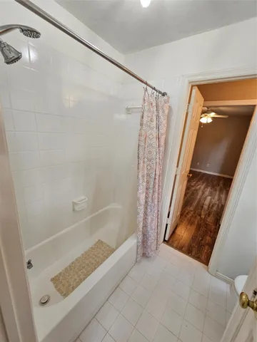 a bathroom with a tub shower and vanity