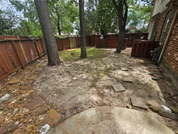 a view of backyard with green space and wooden fence
