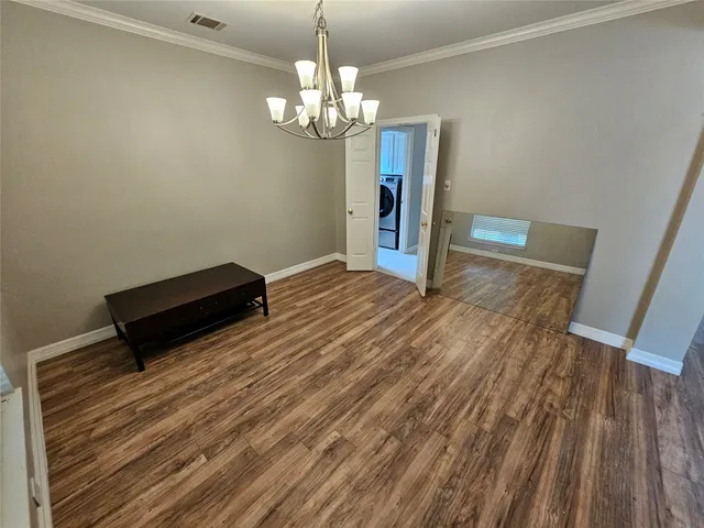 a view of a room with wooden floor and chandelier