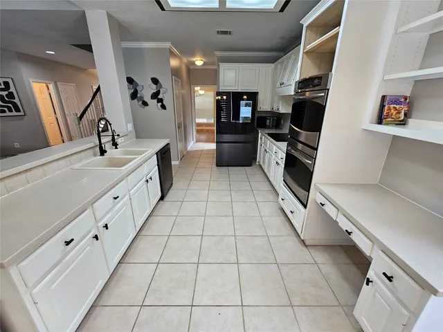 a large white kitchen with a stove a sink dishwasher and a refrigerator