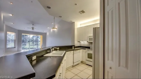 a kitchen with a sink window and cabinets
