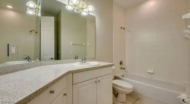 a bathroom with a granite countertop sink a toilet and bathtub