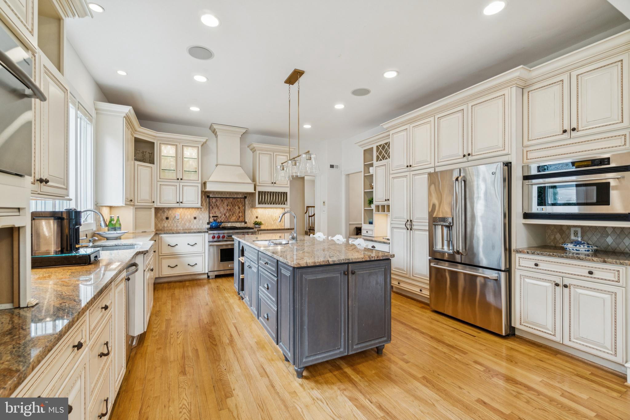 4406 Stanford Street Chevy Chase, MD 20815 - Photo 9 of 49 a kitchen with stainless steel appliances granite countertop a refrigerator oven a sink dishwasher and white cabinets with wooden floor