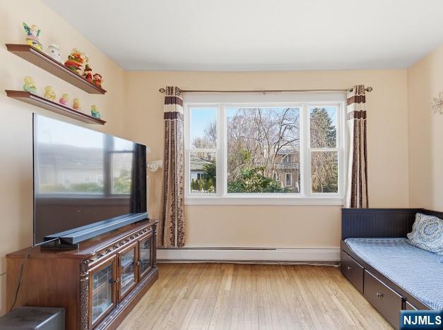 166 Summit Cross Rutherford, NJ 07070 - Photo 7 of 49 a living room with a flat screen tv on dresser and a wooden floor