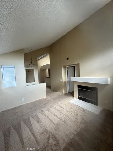 a view of an empty room with a fireplace and a window