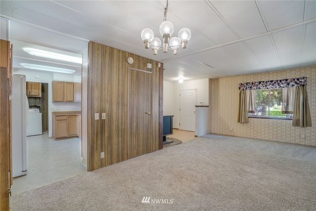 en empty room with chandelier and windows