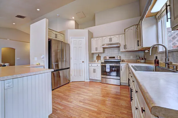 a kitchen with stainless steel appliances granite countertop a refrigerator and a stove top oven