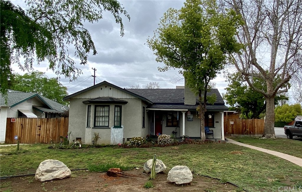 a front view of a house with a garden and trees