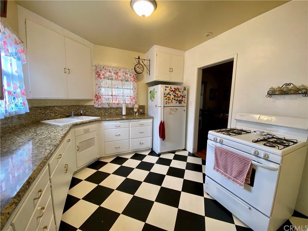 130 Pacific Street Bakersfield, CA 93305 - Photo 9 of 25 a kitchen with granite countertop stainless steel appliances a stove a sink and a refrigerator