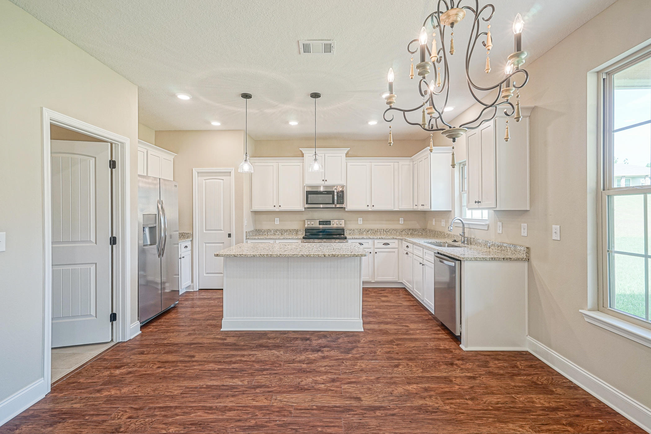 6193 Timberland Ridge Drive Crestview, FL 32539 - Photo 22 of 37 a large kitchen with granite countertop a white cabinets stainless steel appliances and a window