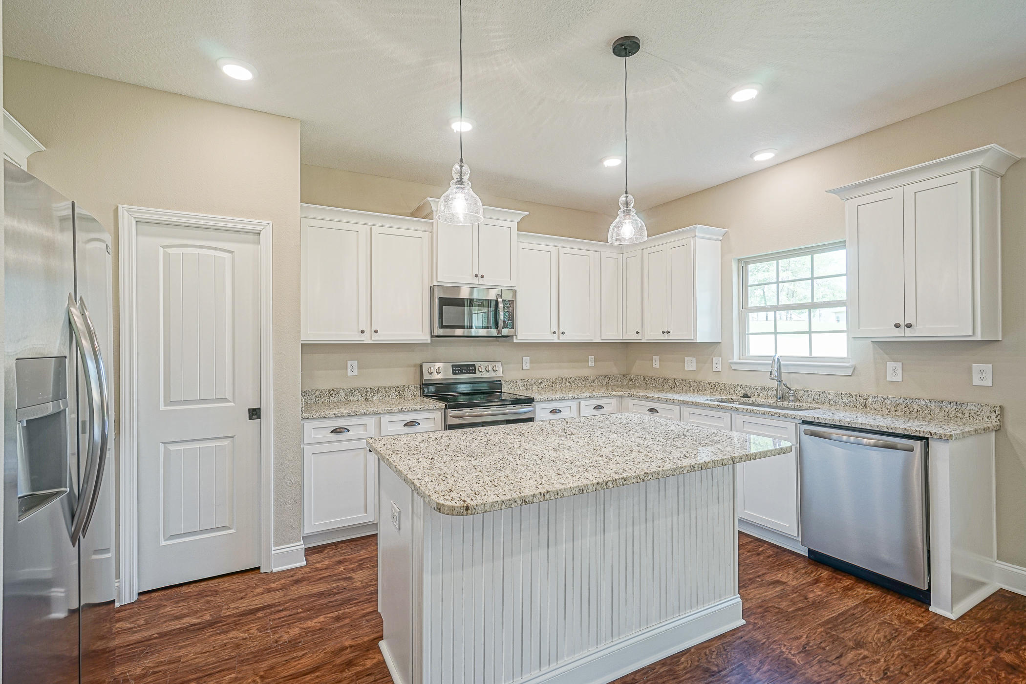6193 Timberland Ridge Drive Crestview, FL 32539 - Photo 23 of 37 a kitchen with stainless steel appliances granite countertop a sink a stove a refrigerator and white cabinets