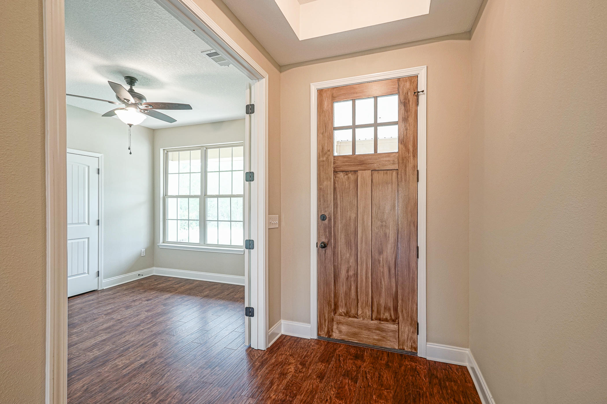 6193 Timberland Ridge Drive Crestview, FL 32539 - Photo 8 of 37 an empty room with wooden floor chandelier fan and windows