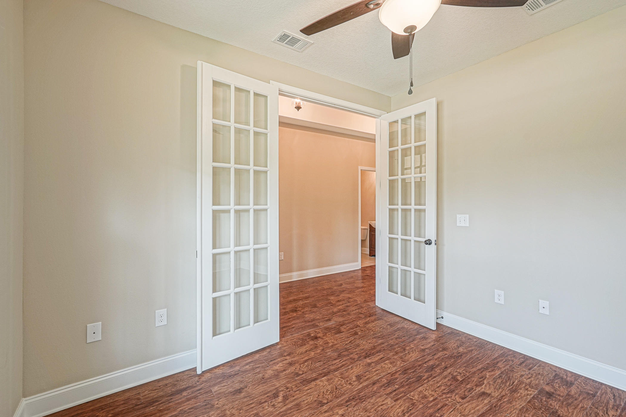6193 Timberland Ridge Drive Crestview, FL 32539 - Photo 10 of 37 an empty room with wooden floor cabinet and windows