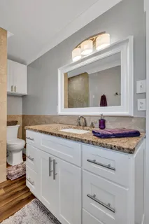 a bathroom with a granite countertop sink and a mirror