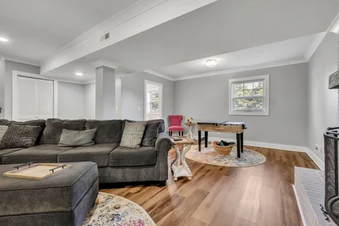 a living room with furniture and a wooden floor