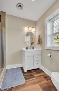 a bathroom with a sink a toilet and a window