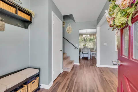 a view of a hallway with wooden floor and stairs