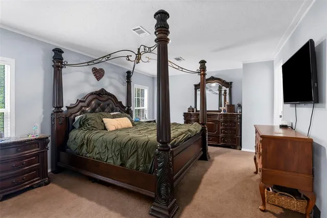 a bedroom with a bed and a flat tv screen on wall