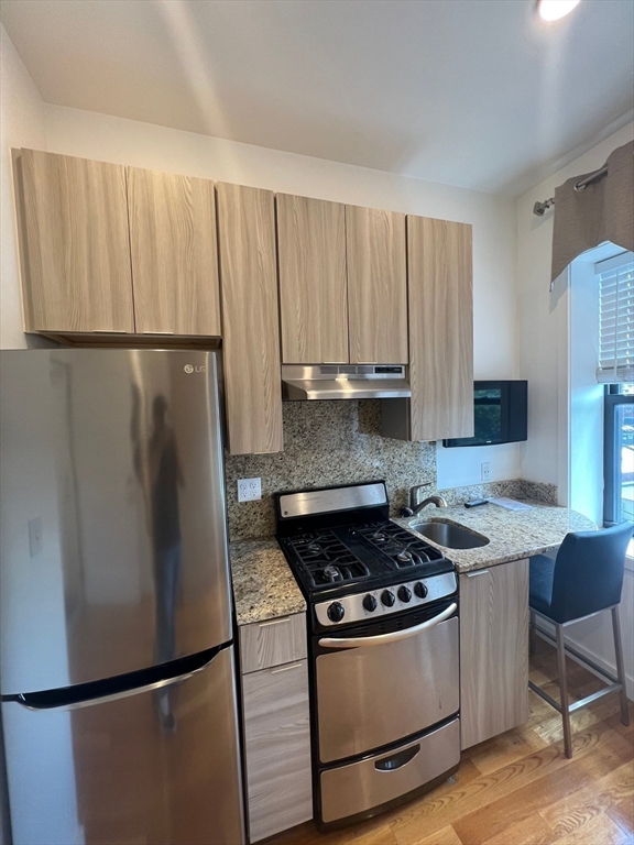 21 5th Street, Unit 26 Chelsea, MA 02150 - Photo 1 of 11 a kitchen with stainless steel appliances granite countertop a refrigerator stove a sink and dishwasher