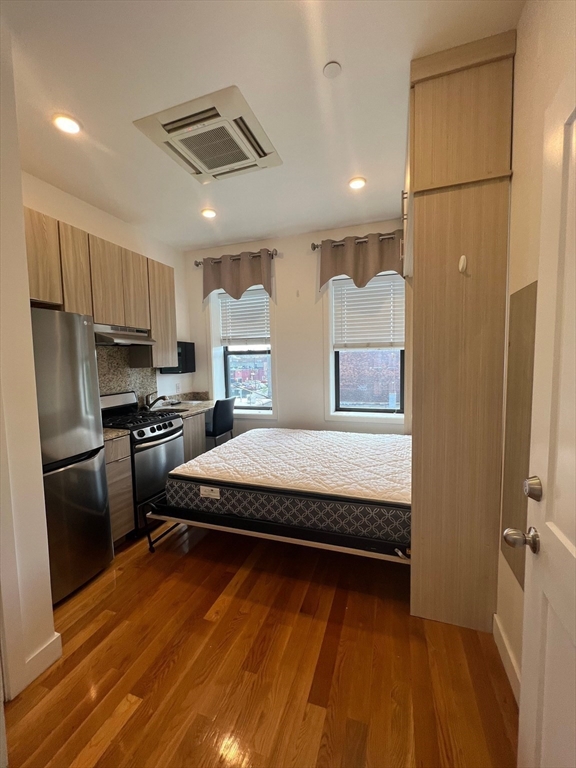 21 5th Street, Unit 26 Chelsea, MA 02150 - Photo 4 of 11 a spacious bedroom with a bed a dresser and cabinets