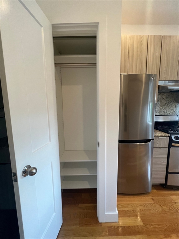 21 5th Street, Unit 26 Chelsea, MA 02150 - Photo 8 of 11 a view of kitchen with a refrigerator electronic appliances and wooden floor