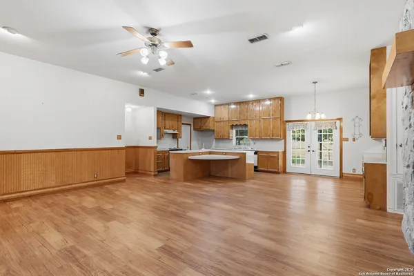 a view of empty room with wooden floor and fan