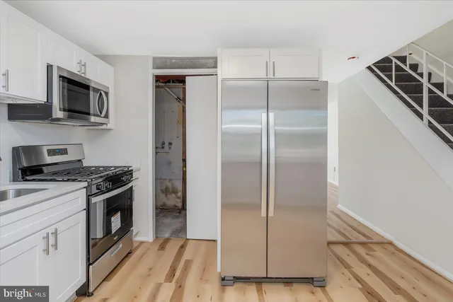 a kitchen with white cabinets and stainless steel appliances