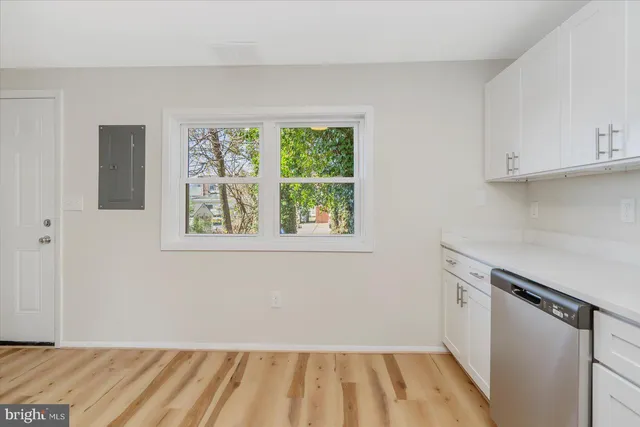 a view of a kitchen with wooden floor and electronic appliances