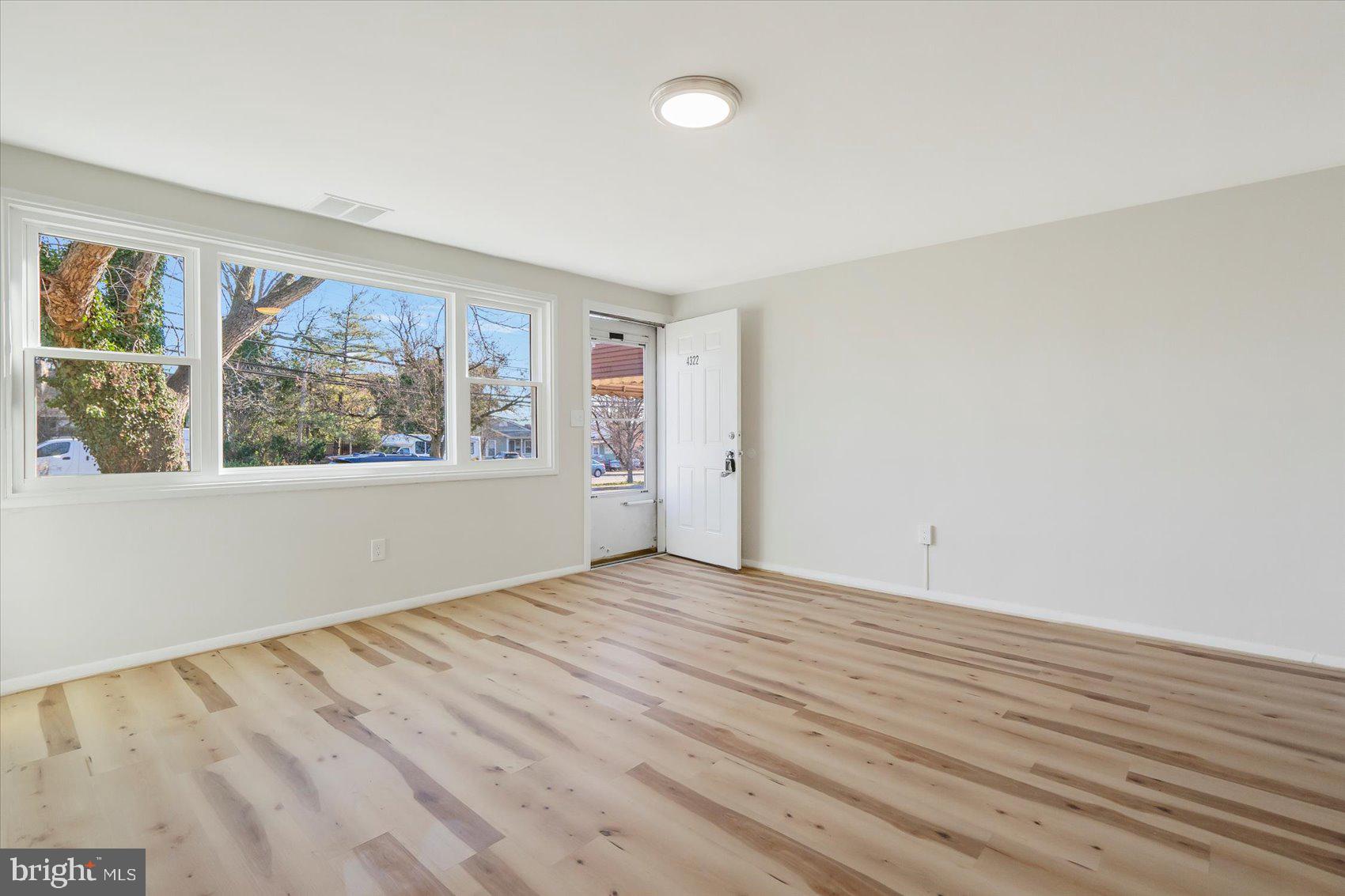 4322 Annapolis Road Baltimore, MD 21227 - Photo 6 of 28 an empty room with wooden floor and windows