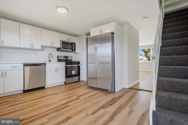 a kitchen with stainless steel appliances granite countertop a refrigerator and a stove top oven