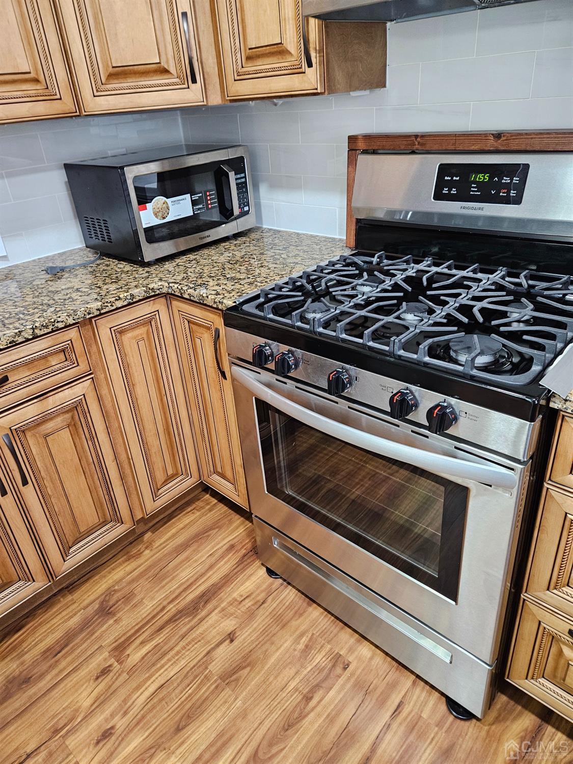 420 Cross Road, Unit 11 Matawan, NJ 07747 - Photo 2 of 15 a kitchen with granite countertop stainless steel appliances stove and cabinets