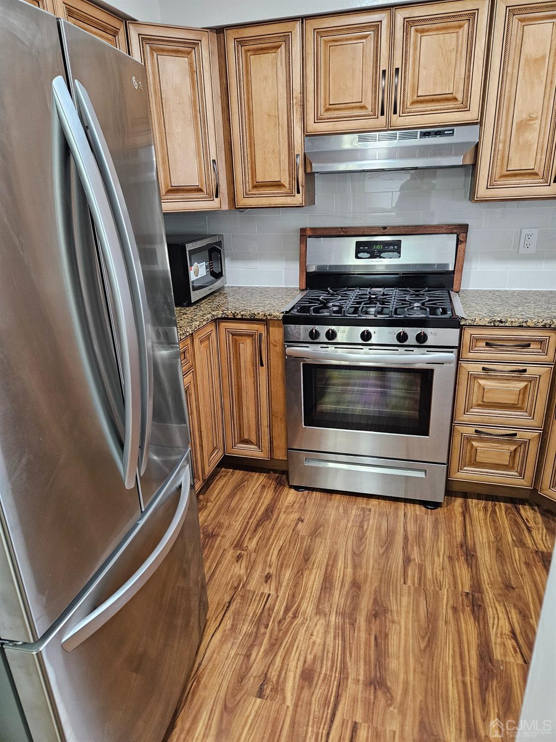 420 Cross Road, Unit 11 Matawan, NJ 07747 - Photo 3 of 15 a kitchen with granite countertop a stove and a refrigerator