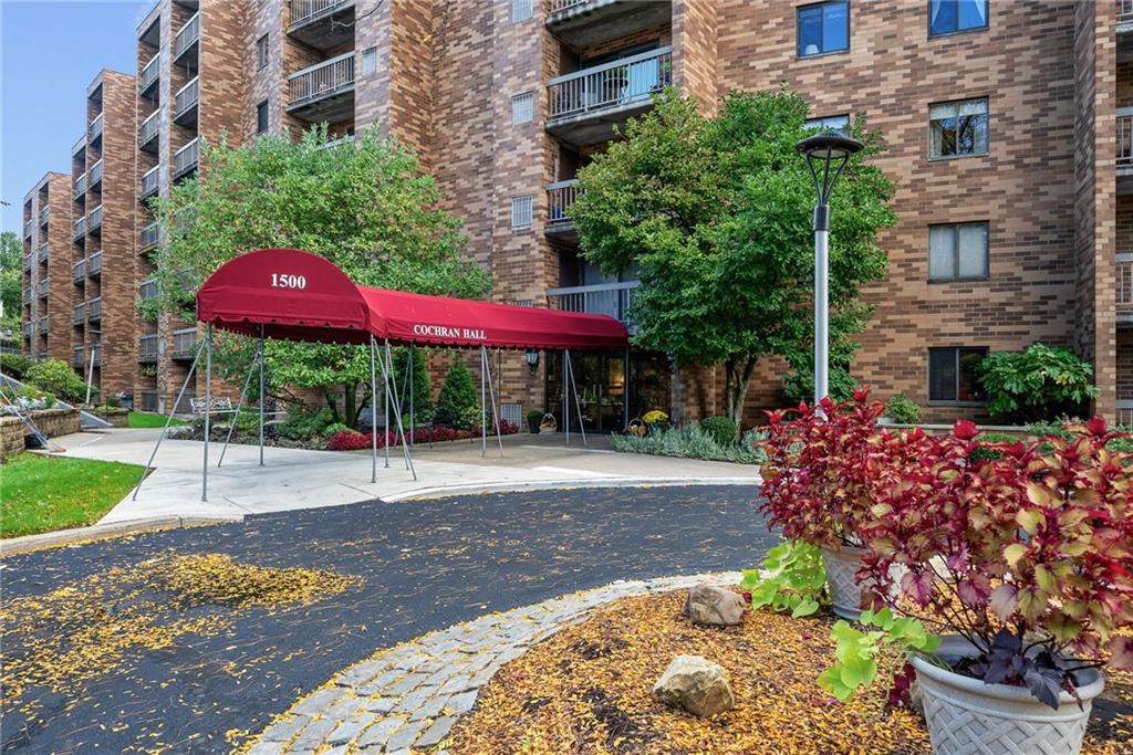 1500 Cochran Road, Unit 412 Pittsburgh, PA 15243 - Photo 3 of 45 a view of a building with a yard and sitting area