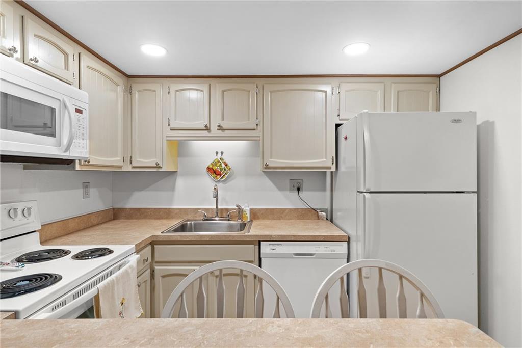 1500 Cochran Road, Unit 412 Pittsburgh, PA 15243 - Photo 9 of 45 a kitchen with stainless steel appliances granite countertop a refrigerator a sink a stove and white cabinets