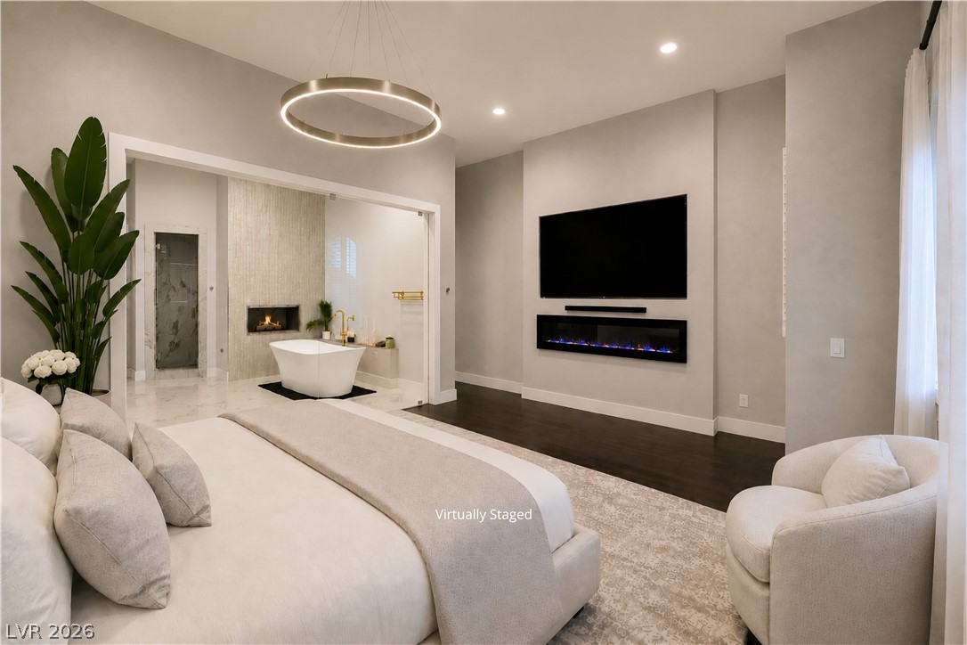 6 Rue Du Ville Henderson, NV 89011 - Photo 12 of 99 “Virtually Staged” spacious bedroom offers a tranquil retreat with an ensuite bathroom, featuring a freestanding tub and fireplace.