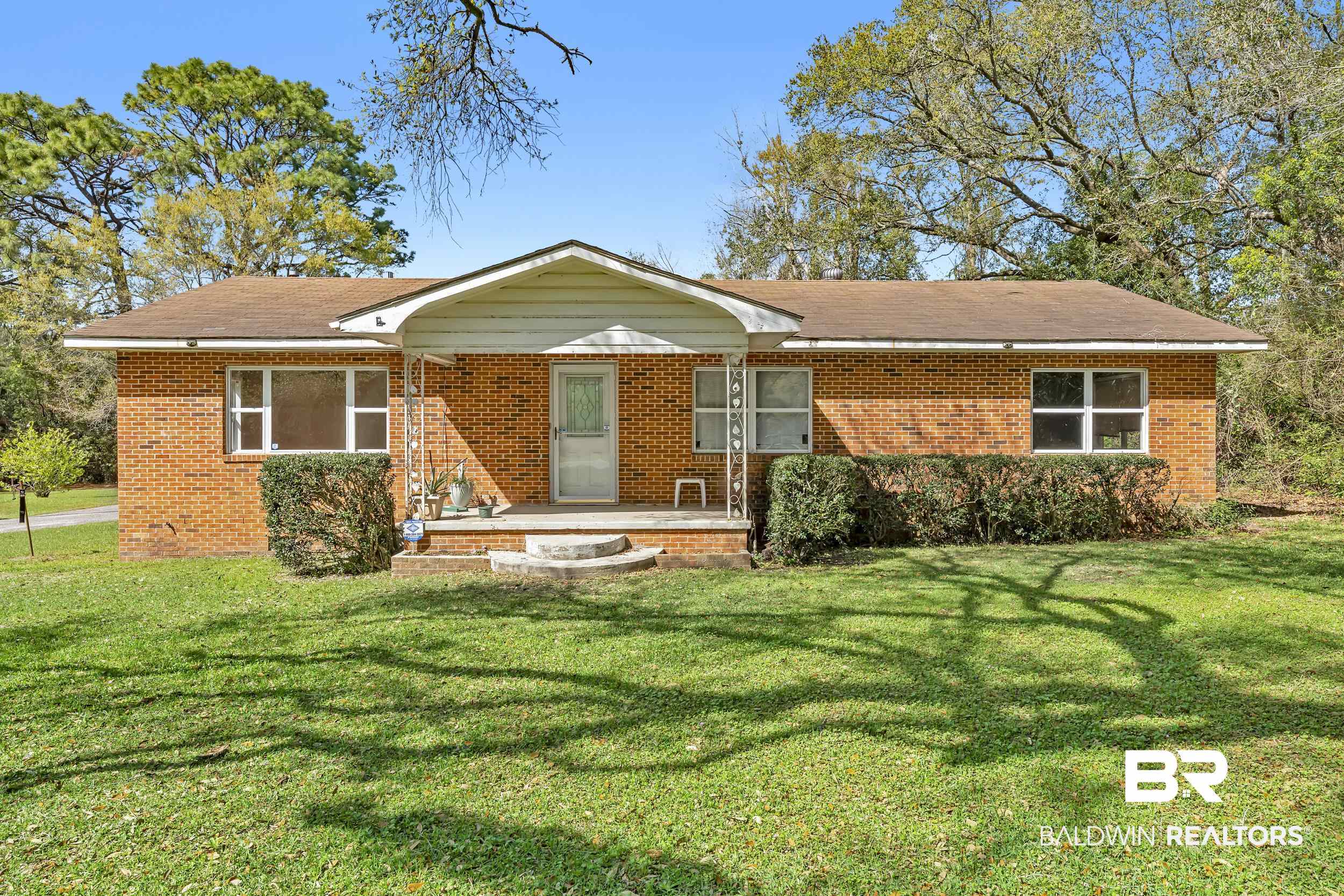 17463 Highway 98 Foley, AL 36535 - Photo 2 of 57 View of front of house featuring brick siding, a front lawn, a porch, and roof with shingles