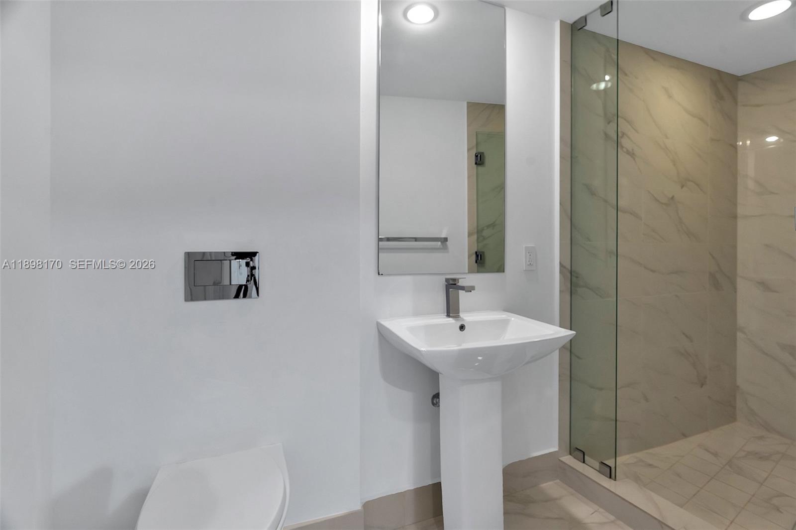 801 South Miami Avenue, Unit 4404 Miami, FL 33131 - Photo 24 of 37 a bathroom with a sink a toilet and mirror