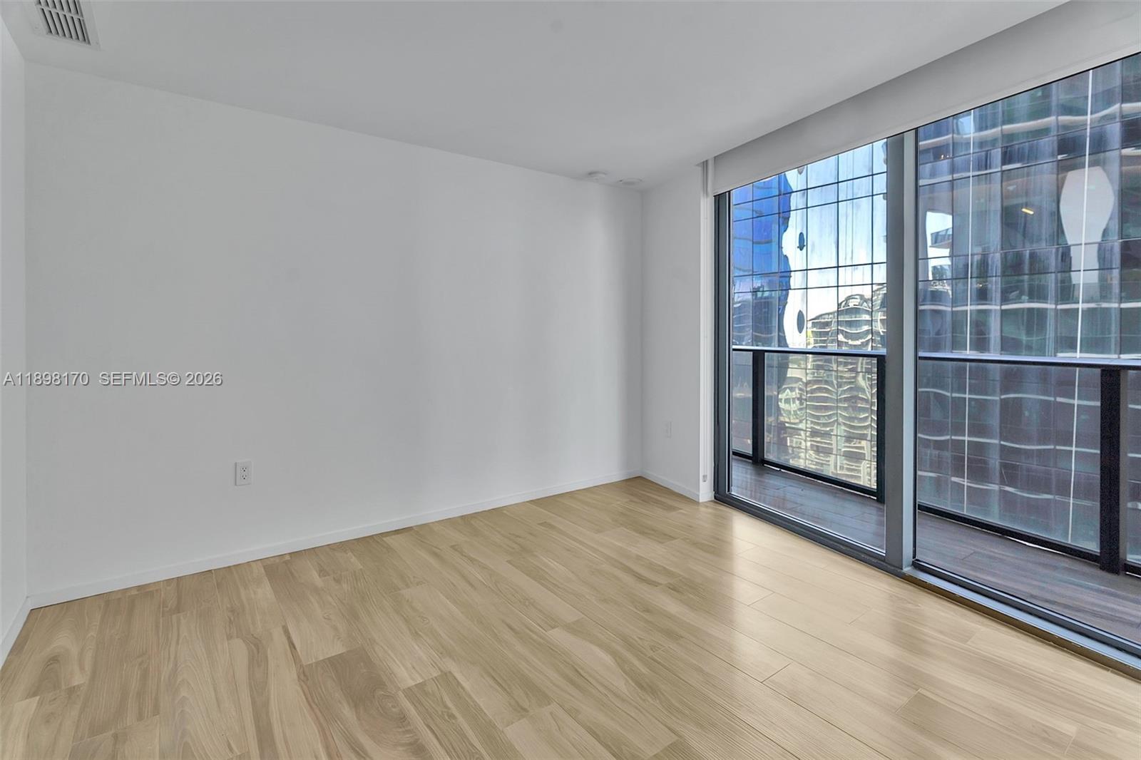 801 South Miami Avenue, Unit 4404 Miami, FL 33131 - Photo 25 of 37 a view of an empty room with wooden floor and a window