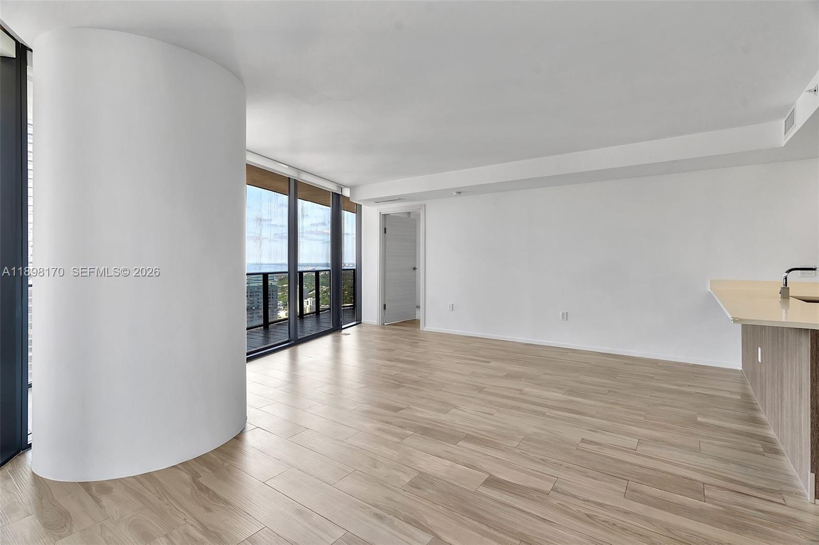 801 South Miami Avenue, Unit 4404 Miami, FL 33131 - Photo 10 of 37 a view of an empty room with wooden floor and a window