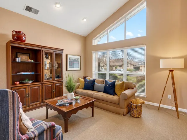 a living room with furniture a rug and a floor to ceiling window