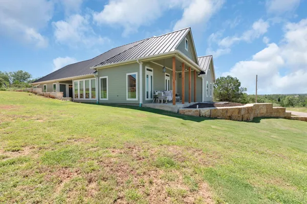 a view of a house with a yard and sitting area