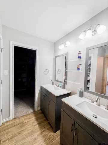 a en suite bathroom with a double vanity sink and a mirror