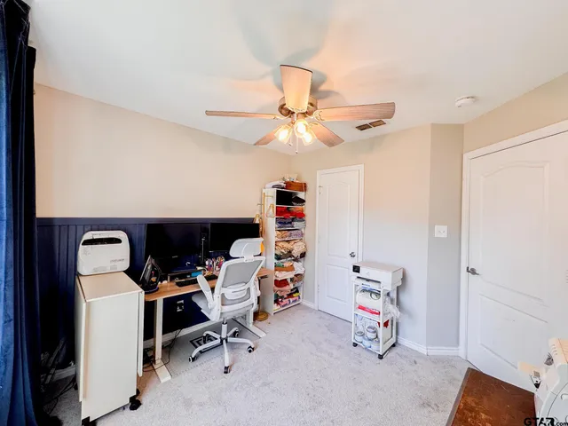 an empty room with windows and fan