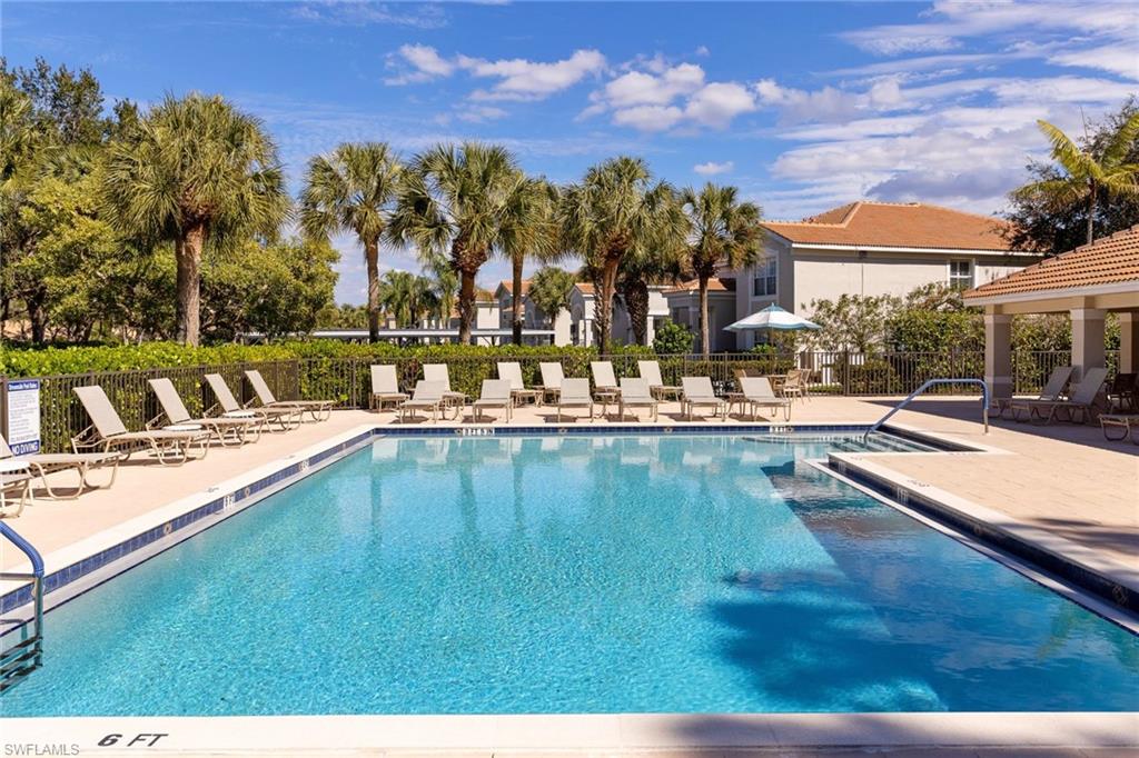 9030 Spring Run Boulevard, Unit 508 Estero, FL 34135 - Photo 38 of 50 a view of a swimming pool with an outdoor seating and a garden